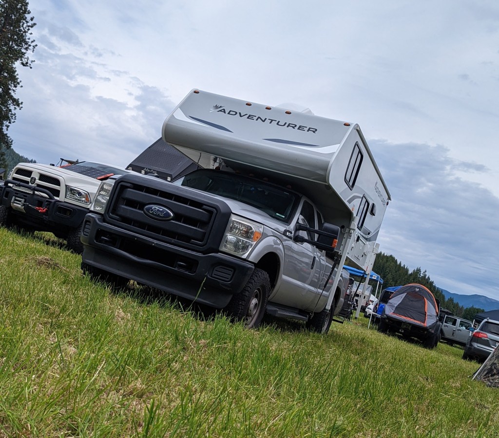 Truck with Slide in Camper in a field